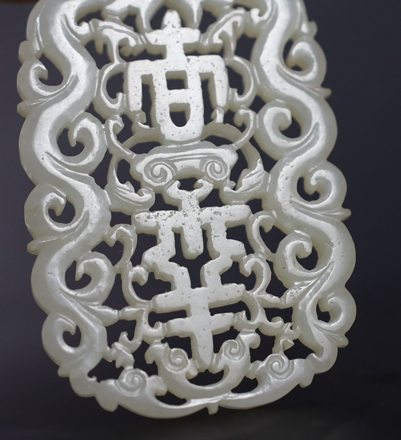 Two Chinese pale celadon jade openwork plaques, 19th century, 5.4 cm and 6.4 cm